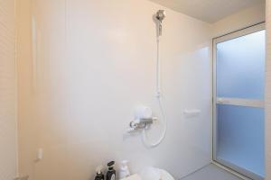a shower in a white bathroom with a glass door at 宿丸一 in Tajimi +32 photos