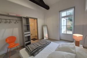 a bedroom with a bed and a chair and a window at Spacious duplex house in Grosbreuil in Grosbreuil