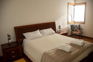 a bedroom with a bed with two towels on it at Quinta da Caselinha in Paredes de Coura +26 photos