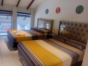 two beds in a room with yellow and brown at Hostal Center A in Santa Cruz de la Sierra +21 photos