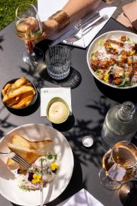 a table with plates of food and glasses of wine at Mooirivier in Dalfsen