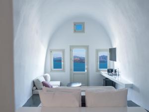a white living room with white chairs and a table at Santonero in Akrotiri