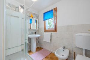 a white bathroom with a sink and a toilet at Rai's Room 1 - Nature and Panoramic View in Stazione Olbia +8 photos