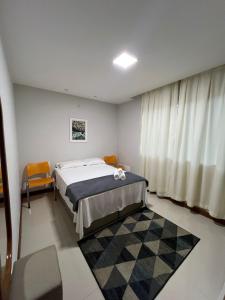 a bedroom with a bed and a window and a rug at Apartamento amplo João VI in Muriaé