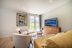 a living room with a couch and chairs and a window at Alpine ski apartment - Petit Chatel in Châtel