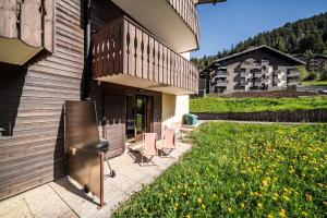 a house with chairs and a balcony on the side of it at Alpine ski apartment - Petit Chatel in Châtel