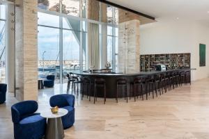 a bar in a large room with chairs and tables at The YACHT - By Fattal Limited Edition in Herzliya B
