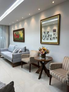 a living room with a couch and two chairs and a table at Apartamento amplo João VI in Muriaé
