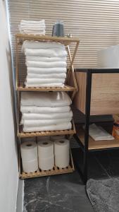 a stack of towels on a shelf in a bathroom at Apartman Noemi in Apševci +30 photos