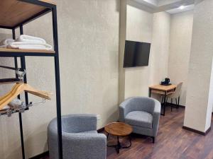 a room with two chairs and a table and a mirror at TAU 28 Hotel in Almaty