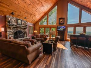 a living room with leather furniture and a stone fireplace at New: Lake Access with Dock Slip More in Swanton