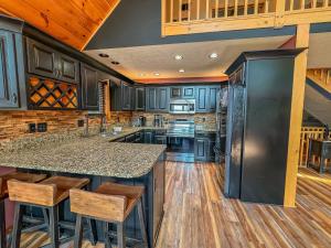 a kitchen with wooden floors and a large island with bar stools at New: Lake Access with Dock Slip More in Swanton