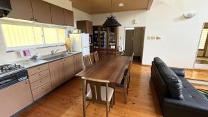 a kitchen with a wooden table and a couch at Garden Villa Minamiaso in Minami Aso