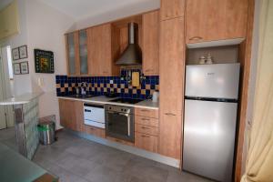a kitchen with wooden cabinets and a refrigerator at Spacious 2 Bd Balcony Apt in Preveza in Preveza