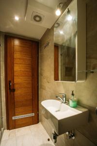 ein Badezimmer mit Waschbecken und Holztür in der Unterkunft Charming old stone house in Sali + 39 Fotos