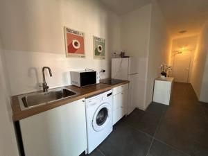 a kitchen with a sink and a washing machine at Residence Greta in Parma