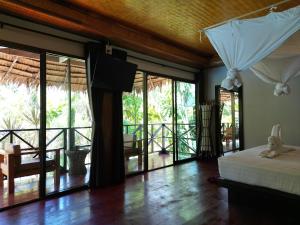 a bedroom with a bed and sliding glass doors at Garden Chalets Koh Lanta in Ko Lanta +32 photos