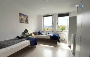 a room with two beds and two windows at BEGE APARTMENTS HomeAway in Marl
