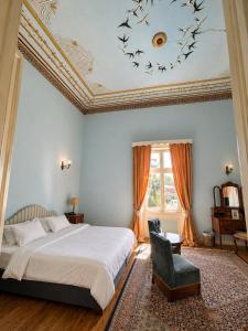 a bedroom with a bed and a chair and a ceiling at Loriet Hotel in Mytilene