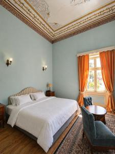a bedroom with a bed and a chair and a window at Loriet Hotel in Mytilene