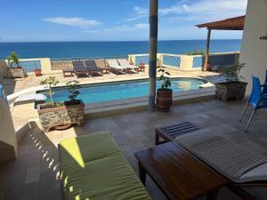 a patio with a pool and chairs and the ocean at Villa MANSOURA avec piscine privative in Driouch