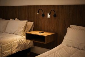 a hotel room with a bed and a night stand with a remote control at Casa Siete Hotel Boutique in Bogotá