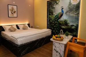 a bedroom with a large peacock painting on the wall at Hotel Amarsar Palace in Amarsar +3 photos