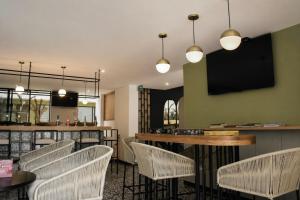 a restaurant with chairs and a bar with a flat screen tv at Casa Siete Hotel Boutique in Bogotá