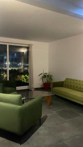 a living room with green furniture and a window at Narjis in Dzaoudzi
