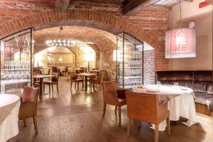 a restaurant with tables and chairs and a brick wall at Palazzo Righini in Fossano