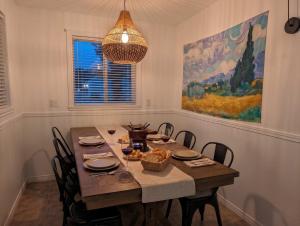 a dining room with a table with chairs and a painting at Chalet #8 Waterfront with Spa, Fireplace, Wifi and AC in Cap-Saint-Ignace