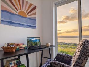 a desk with a laptop and a chair in front of a window at Chalet #8 Waterfront with Spa, Fireplace, Wifi and AC in Cap-Saint-Ignace