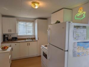 a kitchen with a white refrigerator and a map on the wall at Chalet #8 Waterfront with Spa, Fireplace, Wifi and AC in Cap-Saint-Ignace +31 photos
