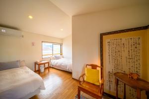 a bedroom with two beds and a table and a mirror at Good MorningHouse in Takayama