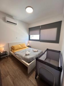a bedroom with a bed and a chair in it at Niko's Modern Family Home near the Beach in Limassol