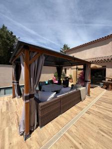 a gazebo on a deck with a table and chairs at Studio piscine in Bouc-Bel-Air