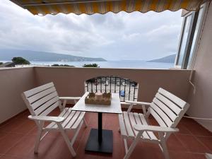 a table and chairs on a balcony with a view of the ocean at Boke vidik in Savina
