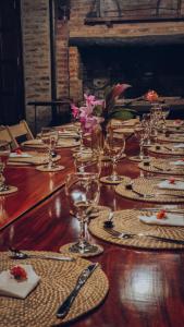 a long wooden table with glasses and napkins on it at Nido de Pajaros Posada Boutique in Concepción