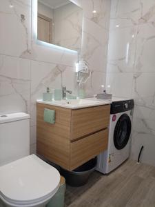 a bathroom with a sink and a washing machine at Celestia Irene Suites 2 in Vromerí +63 photos