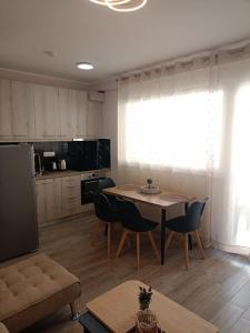 a living room with a table and chairs and a kitchen at Celestia Irene Suites 2 in Vromerí
