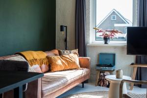 a living room with a couch and a window at Strandweg Appartement in Buren