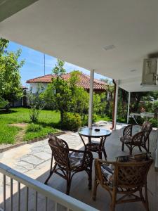 a patio with chairs and a table on a porch at Villa Aspri in Nea Kallikrateia