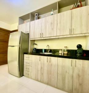 a kitchen with wooden cabinets and a stainless steel refrigerator at Lovely 2BD City Condo with parking in Guayaquil