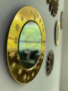 a gold mirror hanging on a wall with a clock at Lovely 2BD City Condo with parking in Guayaquil