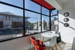 a room with windows and a white table and chairs at Safi Self-catering Suite 2 in Bunkers Hill