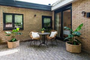 a patio with a table and chairs and plants at Van Heeckeren City Centre Studios Nes in Nes