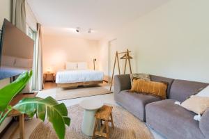 a living room with a couch and a bed at Van Heeckeren City Centre Studios Nes in Nes