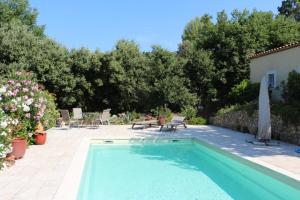 a swimming pool in a yard with chairs and a table at La Bastide des Marcassins in Moissac-Bellevue