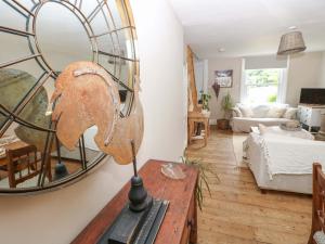 a living room with a mirror on a table at Fern Cottage in Bembridge