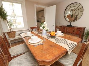 a dining room with a wooden table with a bowl of fruit at Fern Cottage in Bembridge +29 photos